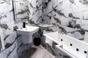 łazienka z umywalką, toaletą i wanną w obiekcie Spire Accommodations Ltd w mieście Bradford