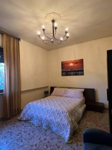 a bedroom with a bed and a chandelier at Casetta dei fiori in Livorno