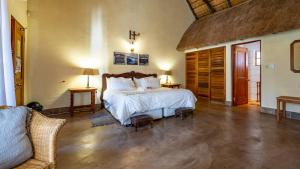 a bedroom with a large bed and a couch at Royal Bakoena Hamiltonparks Country Lodge in Hazyview