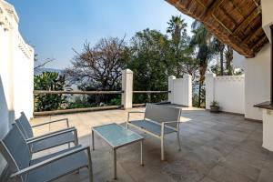 a patio with two chairs and a table and chairs at Royal Bakoena Hamiltonparks Country Lodge in Hazyview