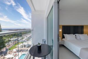 a bedroom with a bed and a view of a city at Napa Mermaid Hotel & Suites in Ayia Napa