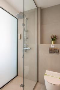 a glass shower door in a bathroom with a toilet at Napa Mermaid Hotel & Suites in Ayia Napa