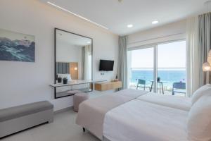 a bedroom with a bed and a view of the ocean at Napa Mermaid Hotel & Suites in Ayia Napa