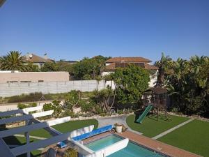 a house with a swimming pool and a playground at Carmel Huys in Cape Town