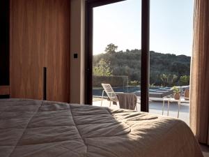 a bedroom with a bed and a large window at Drallos Luxury Villa in Alikanas