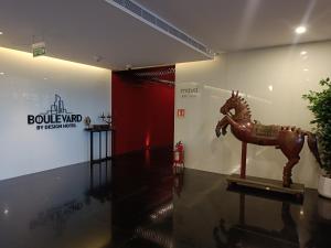 a room with a wooden horse statue on the wall at Boulevard by Design Hotel Chennai in Chennai