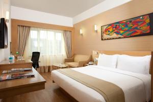 Un pat sau paturi într-o cameră la Lemon Tree Hotel Chandigarh