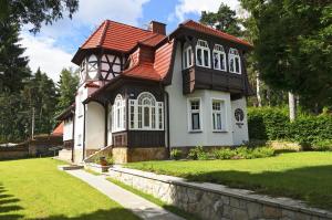 una casa blanca y negra con techo rojo en Villa Dębowa, en Polanica-Zdrój