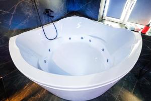 a white bath tub in a bathroom with a window at HouseX in Krasnodar