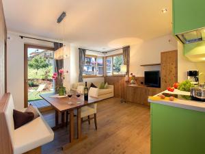a kitchen and a living room with a table in a kitchen at Apartments Cornelia in Castelrotto