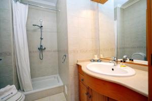 a bathroom with a sink and a shower at Galé Holiday Apartment in Lagos in Lagos +15 photos