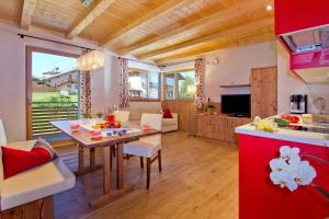 a kitchen and living room with a table and chairs at Apartments Cornelia in Castelrotto +5 photos