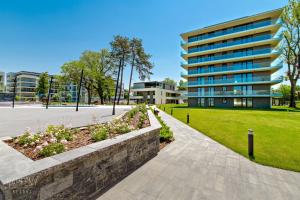 a park in front of a building at Premium Lelle Waterfront Resort Bonnie in Balatonlelle