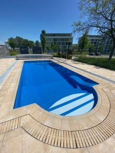 a swimming pool with blue water in a building at Premium Lelle Waterfront Resort Bonnie in Balatonlelle