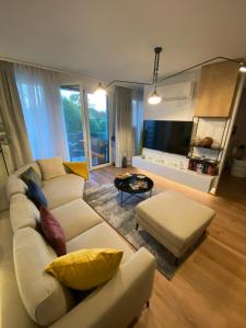 a living room with a white couch and yellow pillows at Premium Lelle Waterfront Resort Bonnie in Balatonlelle