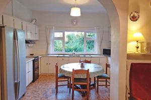 een keuken met een tafel en stoelen en een raam bij Bealadangan Holiday Home 