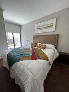 Comfort Center Inn في قرطبة: غرفة نوم مع سرير كبير مع بطانية ملونة