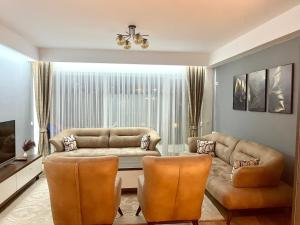 a living room with a couch and two chairs at DAF apartaments in Pristina
