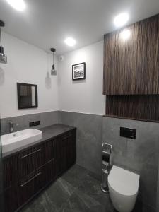 a bathroom with a toilet and a sink at Fajny apartament z parkingiem, obok metra. in Warsaw