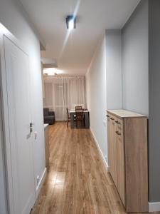an empty room with a hallway with a table at Fajny apartament z parkingiem, obok metra. in Warsaw