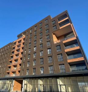 a tall brick building with windows and a blue sky at DAF apartaments in Pristina