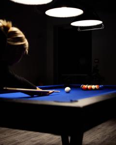 a woman playing pool in a dark room at Hótel Kría in Vík
