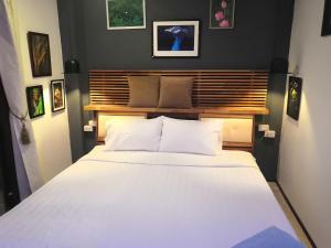 1 dormitorio con 1 cama grande con sábanas blancas en Max's Beach House, en Pattaya South