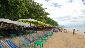 un gruppo di sedie e ombrelloni in spiaggia di Max's Beach House a Pattaya Sud