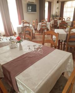 a dining room with tables and chairs with white table cloth at Vila Boema in Marghita