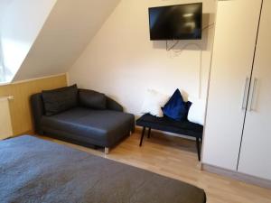 a small living room with a couch and a tv at Ferienwohnung altes Steinlager in Oderberg