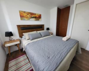 a bedroom with a large bed and a night stand at Departamentos Concepcion Centro in Concepción