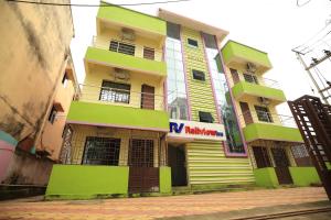 um edifício amarelo e verde com um sinal nele em Railview inn Bhubaneswar em Bhubaneshwar