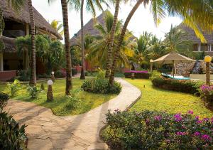 a resort yard with palm trees and a walkway at Tembo Court Apartments in Malindi