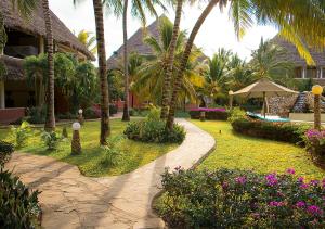 un patio del complejo con palmeras y una pasarela en Tembo Court Apartments en Malindi