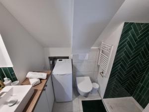 La salle de bains est pourvue de toilettes et d'un lavabo. dans l'établissement Le Cœur d’Artichaut by Madame Conciergerie, à Bruz