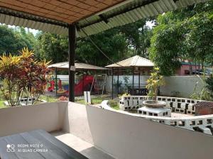 un patio al aire libre con mesa y sombrillas en Almas Hotel Sylhet en Debpur