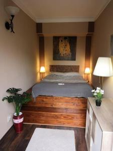 1 dormitorio con 1 cama de madera y 2 lámparas en Lake Park Residence, en Budapest