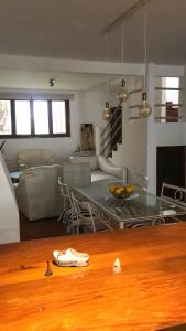 una cucina e un soggiorno con tavolo in vetro di Chalet Gasset a Mar del Plata