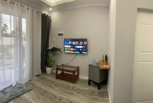 a room with a tv on a wall with a table at Palm View Moalboal in Moalboal