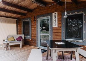 a patio with a table and a bench on a deck at destinature Dorf Südeifel in Ernzen