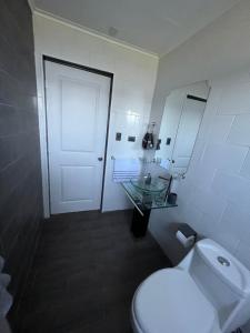 een badkamer met een toilet, een wastafel en een deur bij LETICE LODGE Chillán in Chillán