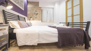 Un dormitorio con una cama grande con sábanas y almohadas blancas. en La Casita de Toledo by Toledo AP, en Toledo