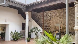 una habitación con una pared de ladrillo y algunas plantas en La Casita de Toledo by Toledo AP, en Toledo
