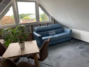 a living room with a blue couch and a table at Meerblick 14 in Grömitz