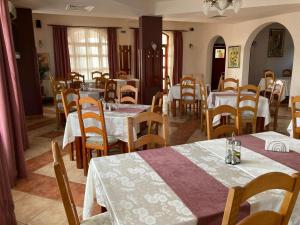 a dining room with tables and chairs in a restaurant at Vila Boema in Marghita