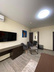 uma sala de estar com uma grande televisão de ecrã plano em Hotel Atmosphere em Poltava