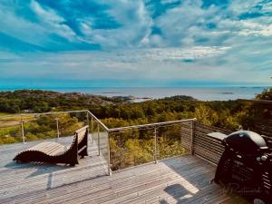 a balcony with a bench and a view of the ocean at Brand new beautiful cabin view Wifi Sonos system in Larvik