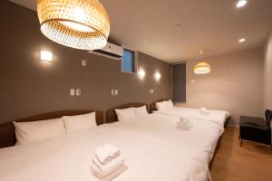 a bedroom with two beds and a chandelier at Hotel AZUMA SEE in Tokyo