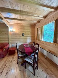 Konjska RekaApartman Mendrea的小屋内带桌椅的用餐室