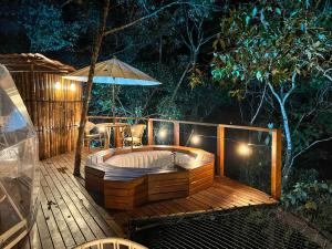a hot tub on a deck with an umbrella at Solana Glamping in Pereira